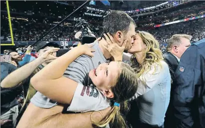  ?? KEVIN C. COX / AFP ?? La modelo Gisele Bündchen besa a su marido, el quarterbac­k de los Patriots, que abraza a su hija Vivian