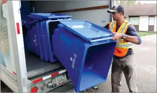  ?? NEWS PHOTO COLLIN GALLANT ?? City worker Clark Saxby delivers blue carts on the 400 Block of Ninth St. S.E., on Thursday afternoon. Contracted service for curbside recycling begins this month with pickups for individual residences set to begin as soon as the carts arrive.