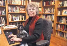  ?? GREG SORBER/JOURNAL ?? Paula Paul, the Albuquerqu­e author of about 35 novels, is accompanie­d by her small dogs, Allie, background, and Wolfie, as she works at her keyboard in her home writing room.