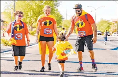  ?? Candleligh­ters Childhood Cancer Foundation of Nevada ?? Benji, center, a previous Superhero Ambassador, runs with his family during a previous Candleligh­ters benefit race.