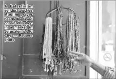  ??  ?? A Palestinia­n vendor touches Muslim prayer beads displayed onsaleathi­sshop in a market in Jerusalem’s Old City. — Reuters photo