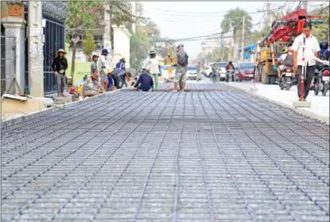  ?? HENG CHIVOAN ?? Constructi­on workers build a road in Phnom Penh’s Sen Sok district on February 6.