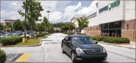  ?? JENNA EASON/JENNA.EASON@COXINC.COM ?? People drive through the Camp Creek Marketplac­e earlier in the week. Center management recently installed approximat­ely 16 security cameras to help stop vehicle break-ins.