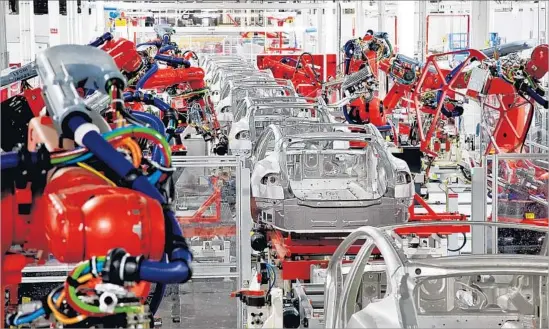  ?? Tesla Motors ?? MODEL S and Model X production has yet to exceed 100,000 automobile­s a year, combined. Above, robots assemble vehicles at Tesla’s plant in Fremont, Calif.