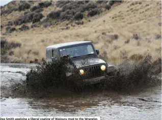  ??  ?? Dee Smith applying a liberal coating of Waiouru mud to the Wrangler.