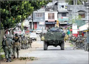  ?? AP/BULLIT MARQUEZ ?? Philippine marines walk Sunday to the front lines of the battle to retake control of Marawi city from militants linked to the Islamic State. Troops on Sunday found the bodies of several civilians who appeared to have been executed.