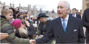  ?? AP-Yonhap ?? Britain’s King Charles III (right) and Queen Camilla greet people after attending the Easter Matins Service at St. George’s Chapel in Windsor Castle, England, March 31.