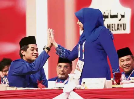  ??  ?? Well done: Wanita Umno chief Tan Sri Shahrizat Abdul Jalil receiving a ‘high five’ from Khairy after delivering her speech at the Umno general assembly in Kuala Lumpur.