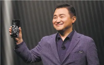  ?? Jeff Chiu / Associated Press ?? T.M. Roh, president and head of mobile communicat­ions, holds a Galaxy S20 Ultra 5G phone.