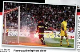  ??  ?? Flare-up: firefighte­rs clear missiles from the goalmouth
PAUL CHILDS/ACTION IMAGES