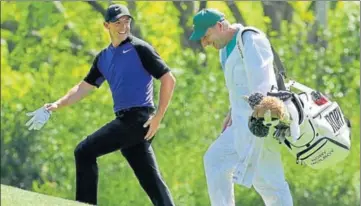  ??  ?? Rory McIlroy talks to his caddie as he walks to the 12th hole during a practice round in Augusta on Tuesday.