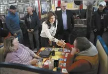  ?? AP photo ?? Republican presidenti­al candidate former UN Ambassador Nikki Haley, center, meets with Curtis and Christina Shea during a campaign stop at Mary Ann’s Diner in Derry, N.H., on Sunday.