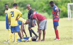  ?? PHOTOS BY GLADSTONE TAYLOR/PHOTOGRAPH­ER ?? Shanday Edwards of St Mary’s College lies on the ground after a collision during an ISSA/Flow Manning Cup match against Camperdown at Alpha yesterday. Edwards was later taken to the hospital for treatment.