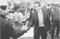  ?? — Gambar Bernama ?? APA KHABAR?: Lim bersalaman dengan para pengunjung pada Majlis Perasmian ‘The Bursa Malaysia Marketplac­e Fair’ di George Town, semaalm. Turut hadir, Ketua Pegawai Eksekutif Bursa Malaysia Datuk Seri Tajuddin Atan (kanan).