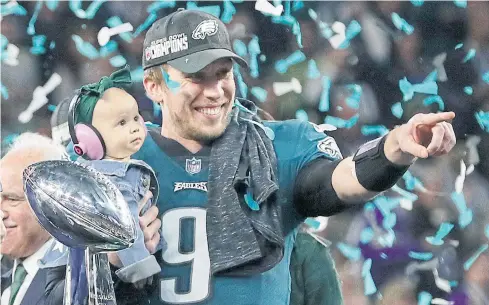  ?? AP ?? Philadelph­ia quarterbac­k Nick Foles holds his daughter Lily next to the championsh­ip trophy after leading the Eagles to victory over the Patriots in the Super Bowl 52.