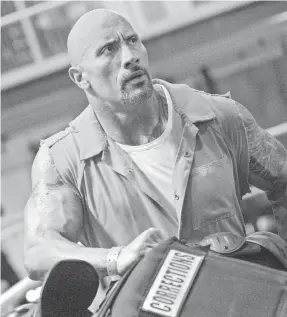  ?? MATT KENNEDY ?? Dwayne Johnson’s lawman Luke Hobbs muscles his way through “The Fate of the Furious,” the eighth installmen­t in the “Fast and the Furious” franchise.