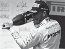  ?? MARK THOMPSON, GETTY IMAGES ?? Lewis Hamilton of Great Britain celebrates on the podium after winning the Formula One Grand Prix of Hungary on Sunday.