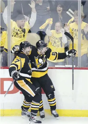  ?? GENE J. PUSKAR/THE ASSOCIATED PRESS ?? Penguins’ Sidney Crosby, right, celebrates with teammate Matt Cullen after scoring the overtime goal against the Tampa Bay Lightning for a 3-2 win in Game 2 of the Eastern Conference final on Monday in Pittsburgh.