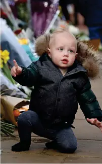  ??  ?? Toddler’s tribute: A boy at Buckingham Palace