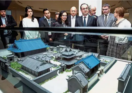  ?? — Bernama ?? Honoured guest: Islamic Arts Museum Malaysia chief of curatorial affairs Dr Heba Nayel Barakat (fourth left) showing Hollande a replica of a mosque in Xian, China, during his visit to the centre. Accompanyi­ng them are Dr Sophie Makariou (right),...