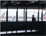  ??  ?? GONZALO FUENTES/REUTERS A passenger walks as Air France planes are parked on the tarmac at Orly Airport near Paris as Air France pilots, cabin and ground crews unions call for a strike over salaries, France, on April 10, 2018.