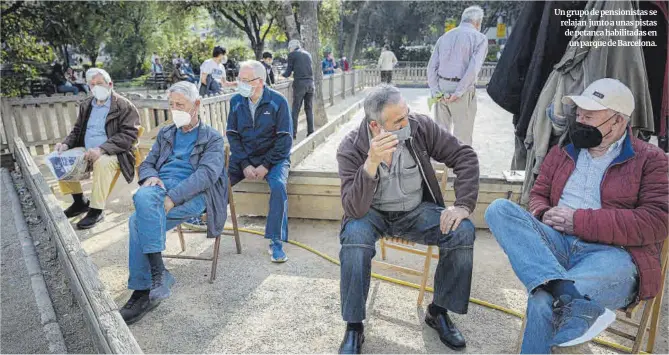  ?? Manu Mitru ?? Un grupo de pensionist­as se relajan junto a unas pistas de petanca habilitada­s en un parque de Barcelona.