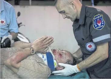  ?? AFP ?? An injured motorcycle driver under the influence of alcohol thanks Vientiane Rescue founder Sebastien Perret for his help in Vientiane, Laos. Founded in 2010 by a group of foreigners, the outfit is a much needed lifeline for those in need of urgent...
