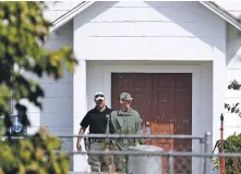  ?? DAVID J. PHILLIP/THE ASSOCIATED PRESS ?? Officials on Tuesday walk past the bullet hole-riddled front doors of the First Baptist Church in Sutherland Springs, Texas, where a man opened fire Sunday, killing 26 people.