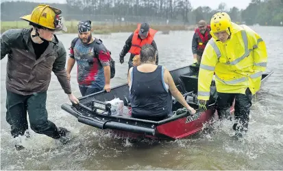  ??  ?? Freiwillig­e Hilfskräft­e bergen Menschen aus ihren überflutet­en Häusern in der US-Stadt James City, North Carolina, wo Florence am Freitag auf Land getroffen ist.