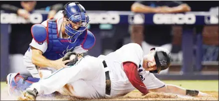  ??  ?? Miami Marlins’ Garrett Cooper is tagged out at home by Los Angeles Dodgers catcher Austin Barnes during the third inning of a baseball game, on July 7, in Miami. (AP)