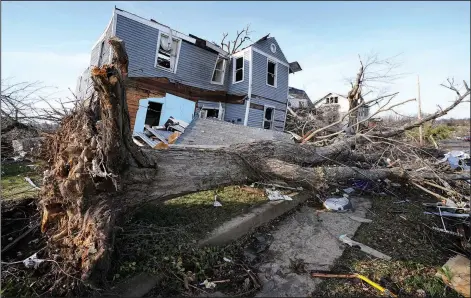  ?? (File Photo/AP/Mark Humphrey) ?? An overturned tree sits in front of a tornado-damaged home Dec. 11, 2021, in Mayfield, Ky. Stories circulatin­g online incorrectl­y claim climate, weather or meteorolog­ical events that would be classified as “extreme” have declined in severity over the last 20 or 30 years.