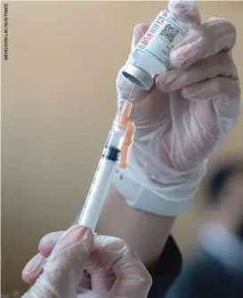  ??  ?? A physician for Lawndale Christian Health Center prepares to administer the Moderna COVID-19 vaccine last month at a Pacific Garden Mission, 1458 S. Canal St.