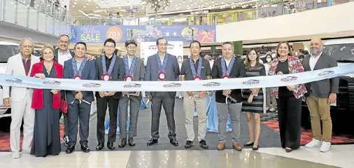  ?? ?? Cutting the ceremonial ribbon are, from left, Amang San Juan, Baby San Juan, Dennis San Juan, Cecil Capacete of Hyundai, Norihide Takei of Suzuki, Takanobu Suzuki of Mitsubishi, Juan Manuel Hoyos of Nissan, Yoshuke Nishi of Fuso, Levy Santos of Foton, Honey Rose dela Cruz of Chery, Atty. Lyne Penforrada, and Leo San Juan.