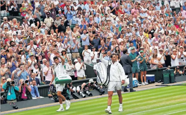  ??  ?? DESPEDIDA. Novak Djokovic y Rafa Nadal saludan a los espectador­es de la pista central de Wimbledon al final del partidazo de semifinale­s cuya continuaci­ón disputaron ayer.