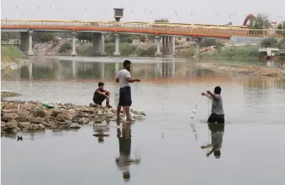  ?? (Essam al-Sudani/Reuters) ?? IRAQI FISHERMEN cast their lines in the Euphrates River in Samawa, Iraq.