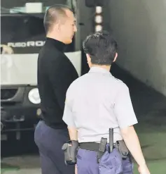  ??  ?? Zhou is escorted by a policeman at the Taipei District Court. — AFP photo