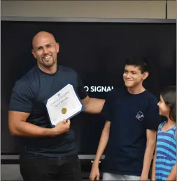  ?? Brennon Dixson/The Signal ?? David Breceda, left, holds up a certificat­e Tuesday from the Saugus Union School District. He was recognized for leading a warehouse reorganiza­tion.