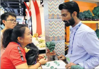  ?? XINHUA ?? A Pakistani retailer introduces jewelry products to Chinese visitors at the China-ASEAN Expo held in Nanning, Guangxi Zhuang autonomous region, last September.