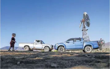  ??  ?? OLD MEETS NEW: Little Hendrik Kotze, 18 months, enjoys his freedom in the shadow of the 1979 Isuzu KB and the latest Isuzu KB which visited the Kotze family