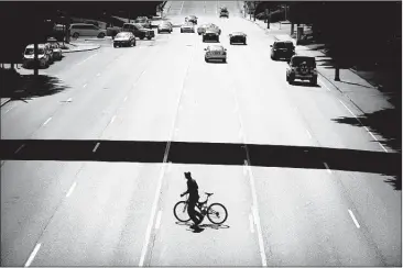  ?? JIM WEBER/THE COMMERCIAL APPEAL ?? A cyclist rushes across six lanes of traffic on Union Avenue near Methodist Hospital on Tuesday. A $950,000 TDOT grant will fund the creation of turn lanes on Union, like this one in front of Methodist, better pedestrian access and a bike lane near the medical center.