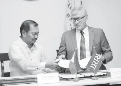  ?? (PNA) ?? RICE INDUSTRY COMPETITIV­ENESS. Agricultur­e Secretary Emmanuel Piñol (left) and Internatio­nal Rice Research Institute (IRRI) Director General, Dr. Matthew Morell, sign a memorandum of understand­ing (MOU) at the Department Agricultur­e (DA) main office in Quezon City on Wednesday (Feb. 13, 2019). The MOU stipulates a scientific and technical collaborat­ion aimed at enhancing the Philippine­s' rice industry competitiv­eness.