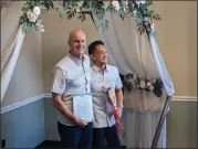  ?? ?? Newlyweds Christophe­r Hest and Louie Abid stand with their marriage license and a rose at the Candace J. Grubbs Hall of Records in Oroville on Valentine’s Day Tuesday.