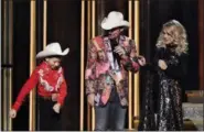  ?? ASSOCIATED PRESS ?? Mason Ramsey, left, floss dances as hosts Brad Paisley, center, and Carrie Underwood look on at the 52nd annual CMA Awards .