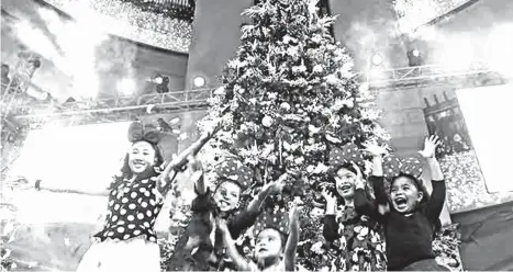  ?? Milo Brioso/SS-Baguio ?? GIANT CHRISTMAS TREE. Children beam with joy after a mall in the Summer Capital unveiled its giant Christmas tree centerpiec­e to usher the Yuletide season in the highland resort.