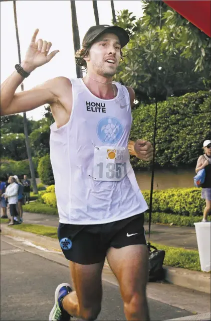  ?? The Maui News / MATTHEW THAYER photo ?? Reid Hunter gives a shaka as he heads to a win in the Day of Hope 10K on Nov. 10, 2018 at the Four Seasons Resort Maui at Wailea. Hunter, a 2009 graduate of King Kekaulike High School, has developed into an elite runner and is also pursuing a career in internal medicine.
