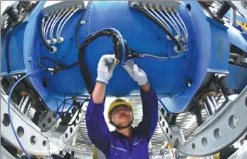  ?? GENG YUHE / FOR CHINA DAILY ?? A technician works on the production line of LNG containers at a plant in Lianyungan­g, Jiangsu province.