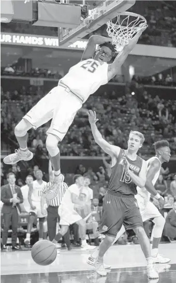  ?? PATRICK SEMANSKY/ASSOCIATED PRESS PHOTOS ?? Maryland forward Jalen Smith, left, dunks over Loyola Maryland forward Sam Norton in the second half. The Terps went on a 19-0 run in a span of less than four minutes in the second half to seal the victory.