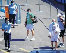  ?? SANDRA SANDERS • REUTERS ?? Tennis players undergoing mandatory quarantine ahead of the Australian Open leave a restricted training area in Melbourne, Australia last Wednesday.