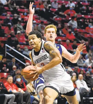  ?? DENIS POROY FOR THE U-T ?? San Diego State guard Matt Bradley drives past UC San Diego’s Bryce Pope during last year’s intracity game.