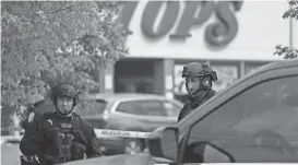  ?? JOSHUA BESSEX/AP ?? Police secure the perimeter around a supermarke­t in Buffalo, N.Y., the site of a mass shooting. Authoritie­s say at least 10 people have been killed and the alleged shooter is in custody.